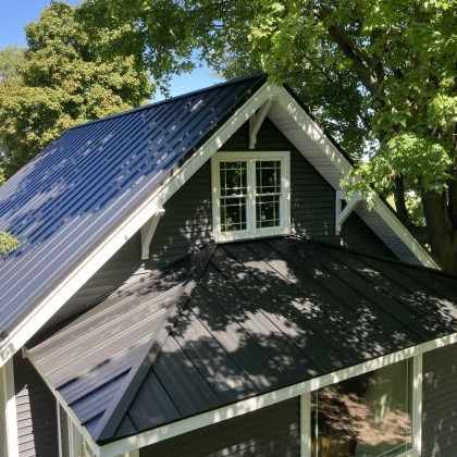 Black metal roof with a dormer and white trim.