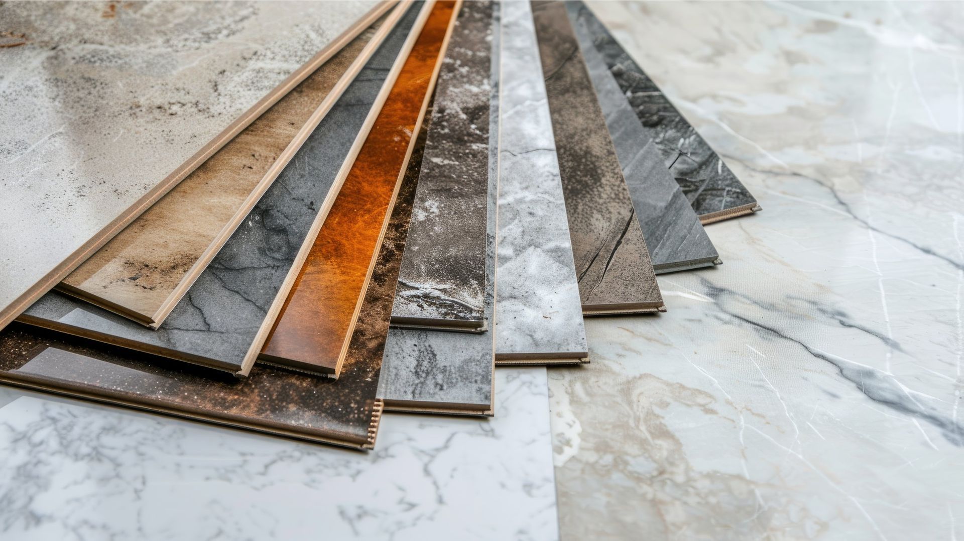 Various wood flooring samples arranged on a marble-patterned surface, showcasing different colors and textures.
