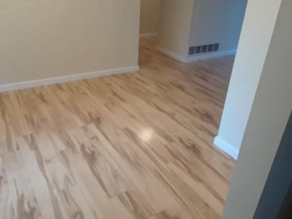 Light wood flooring in a room with white trim and beige walls.