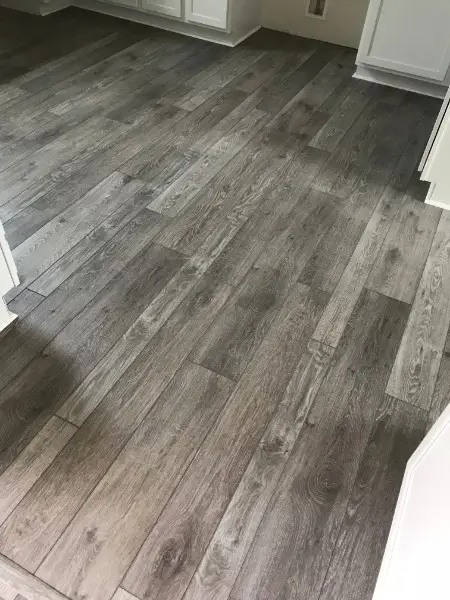 Gray, wood-look flooring installed in a room. Boards run diagonally across the space.