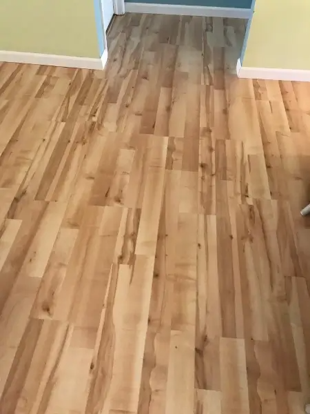 Wooden floorboards in a room, varying shades of light brown and tan.