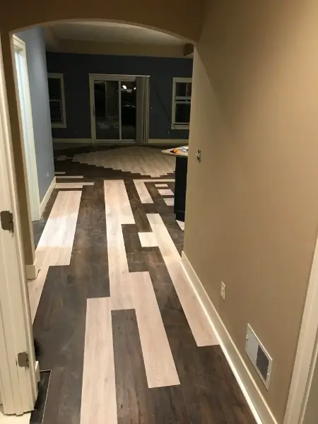 Hallway with new wood flooring, light and dark planks in a geometric design.