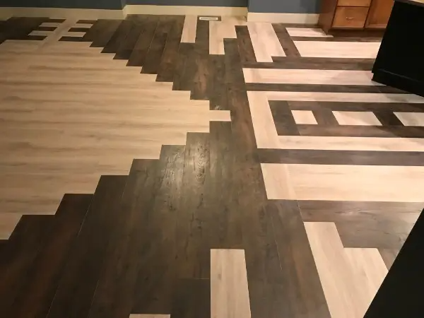 Wooden floor with a geometric pixelated design in light and dark brown.