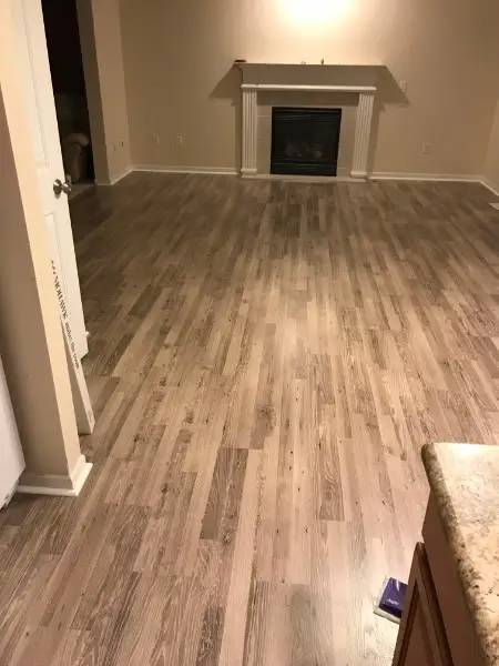 Wooden floors in a room with a fireplace and white trim.