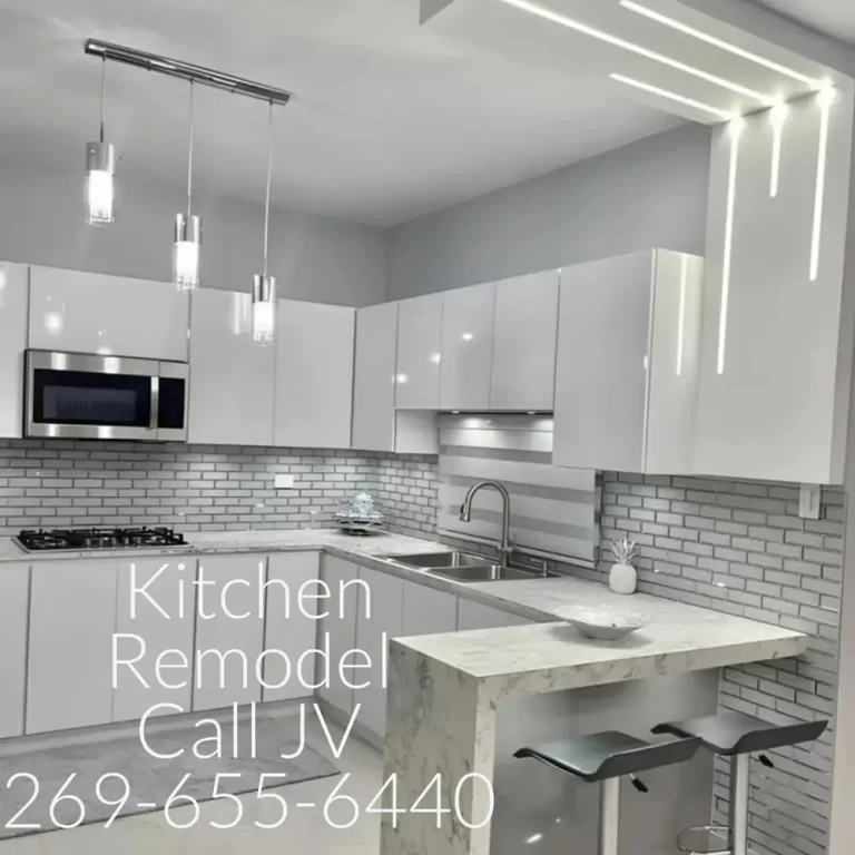 Modern kitchen remodel with white cabinets, stainless steel appliances, and gray accents.