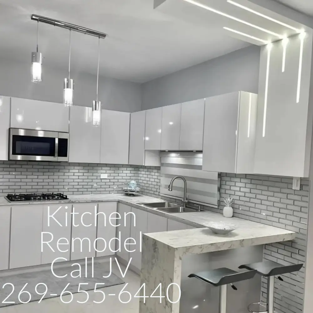 Modern white kitchen with stainless steel appliances and bar seating. Kitchen remodel call JV 269-655-6440.