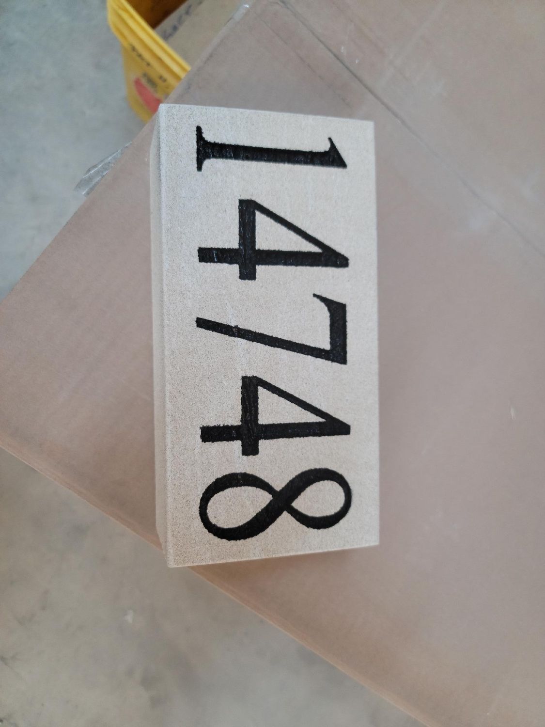 Rectangular address plaque with black numbers 14748 on a light textured background.