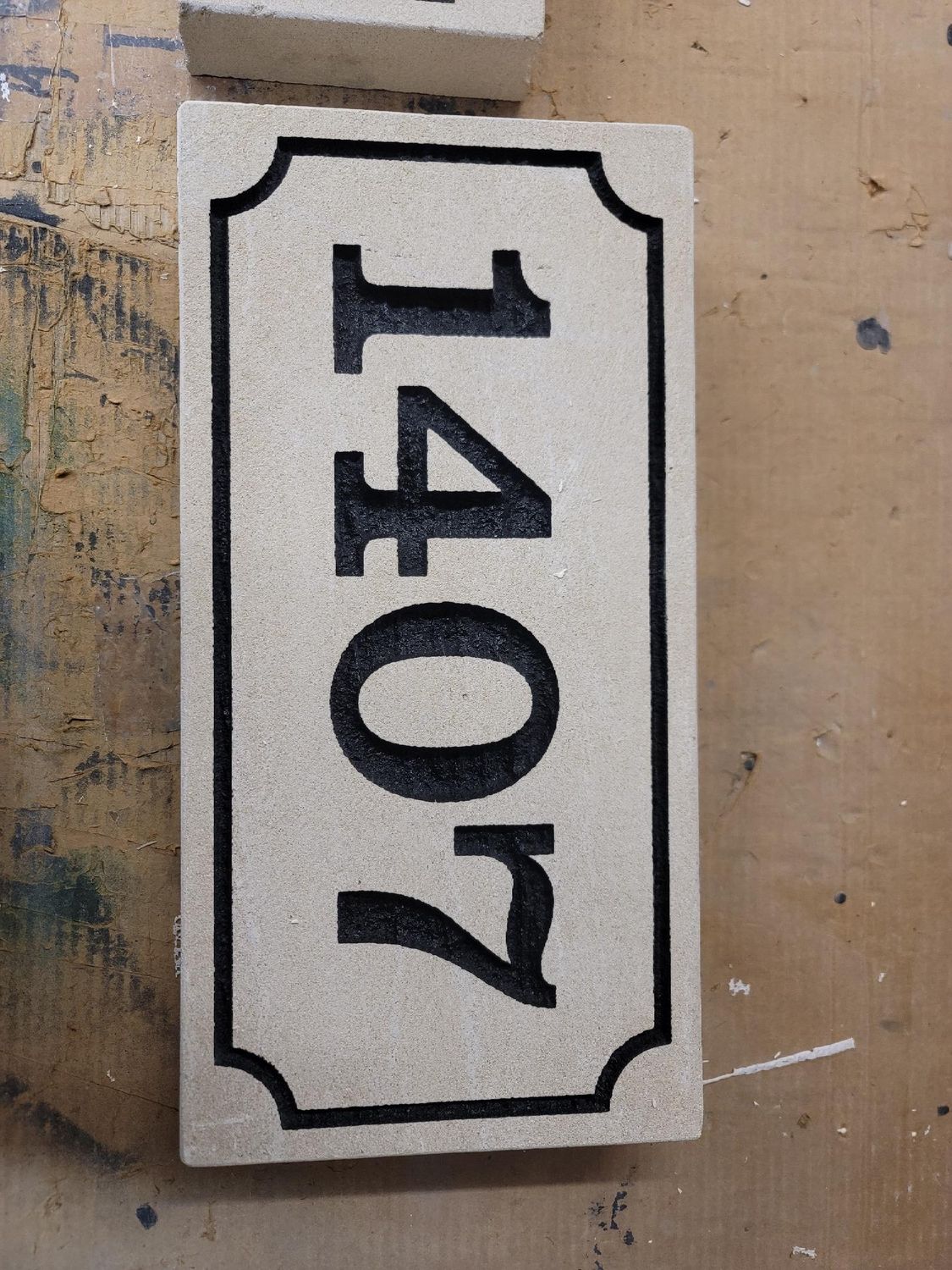 House number sign: 1407 in black, rectangular with rounded corners, on a light brown background.