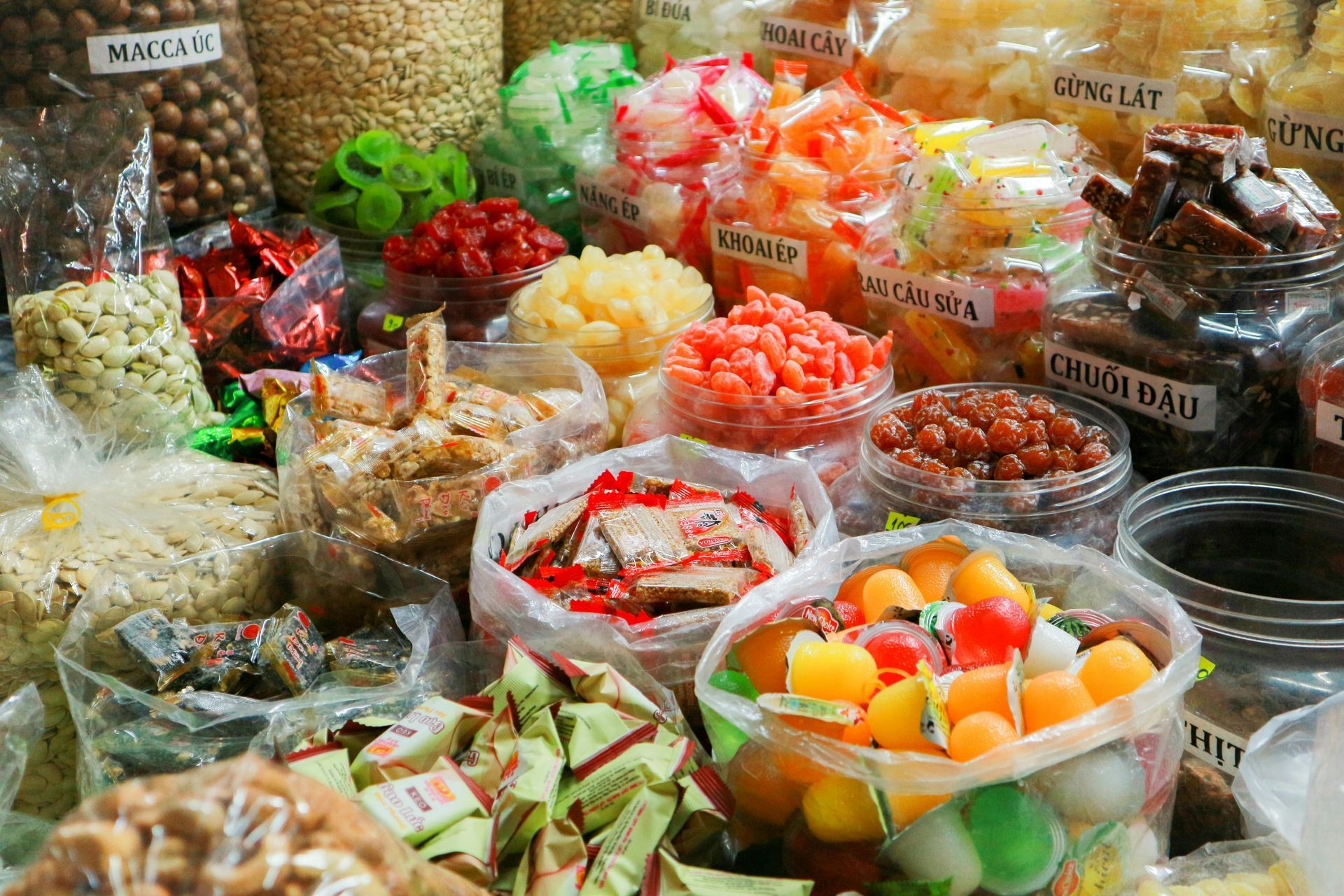 Assorted colorful packaged snacks and candies displayed in a market stall