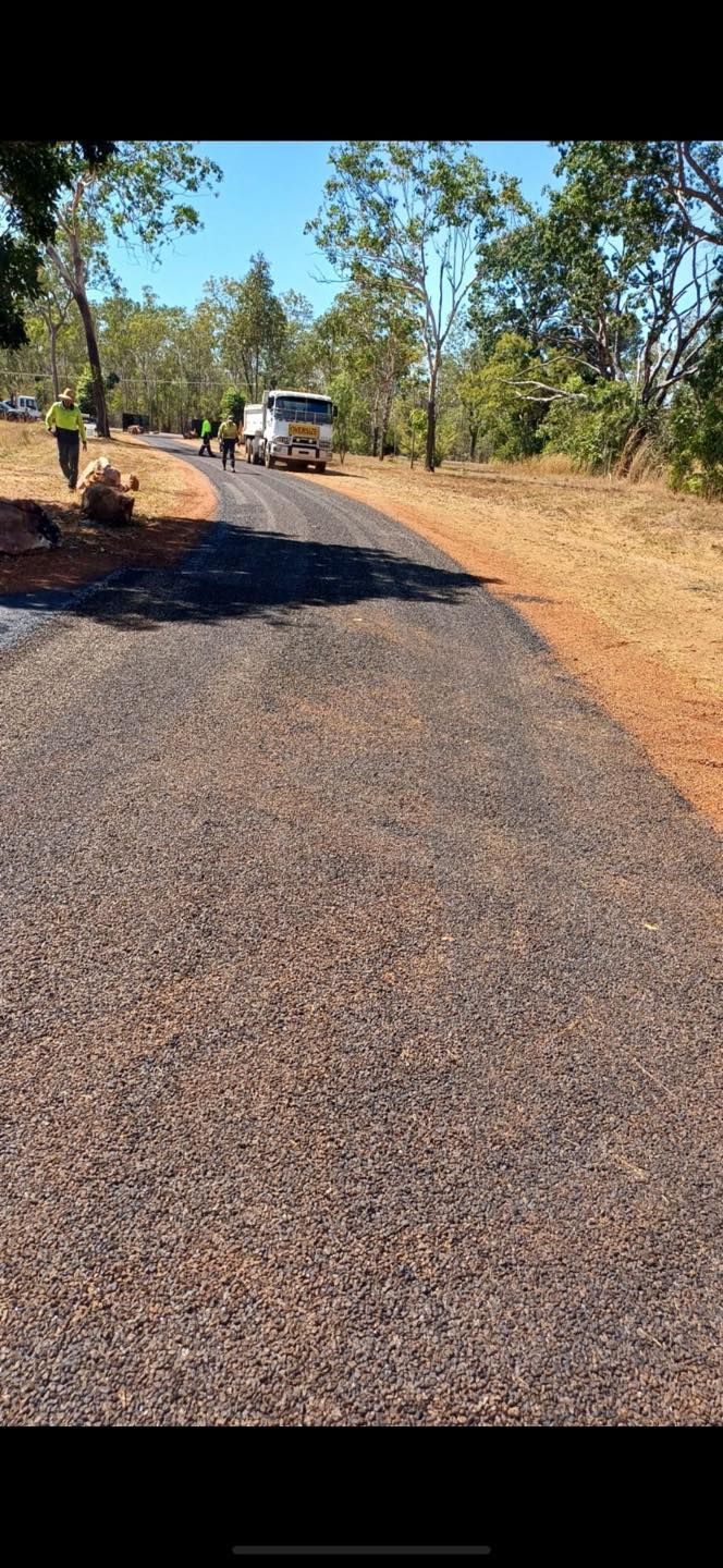A Yellow Roller Is Rolling Asphalt On A Driveway — Territory Bitumen Services In Tivendale, NT