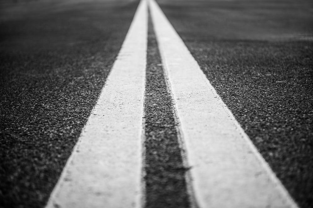 A Black And White Photo Of Two White Lines On A Road — Territory Bitumen Services In Tivendale, NT