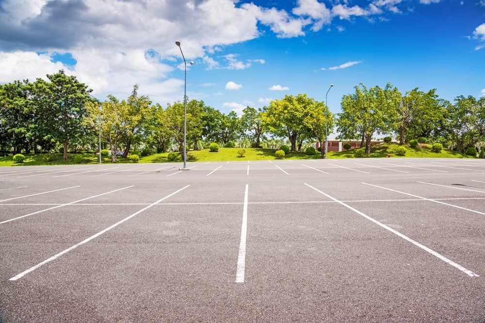 An Empty Parking Lot With Trees In The Background On A Sunny Day — Territory Bitumen Services In Tivendale, NT