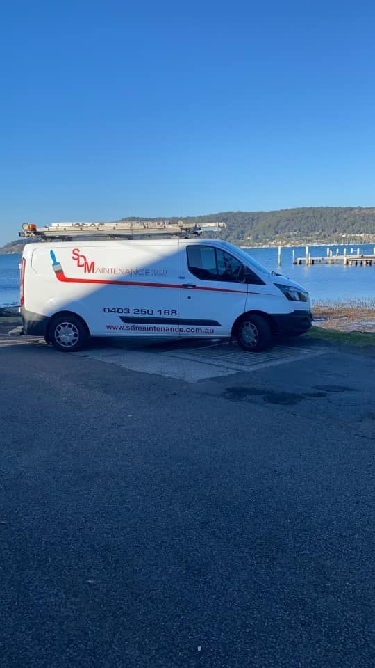 White Service Van Parked Near a Body of Water Under a Clear, Blue Sky — S D Maintenance In Point Clare, NSW