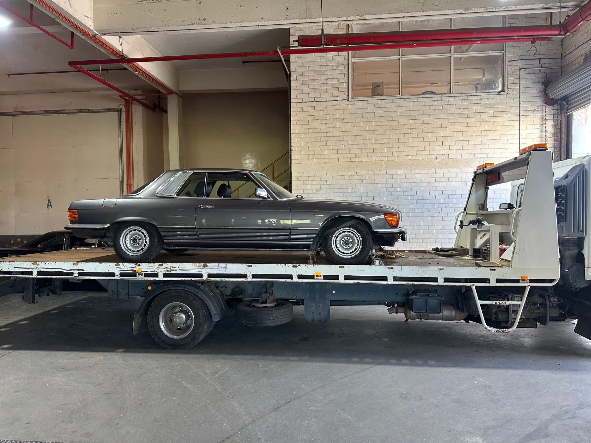 Black Vintage Coupe on A Tow Truck Inside a Garage — Connect Trailers and Towing Pty Ltd In Prospect Vale, TAS