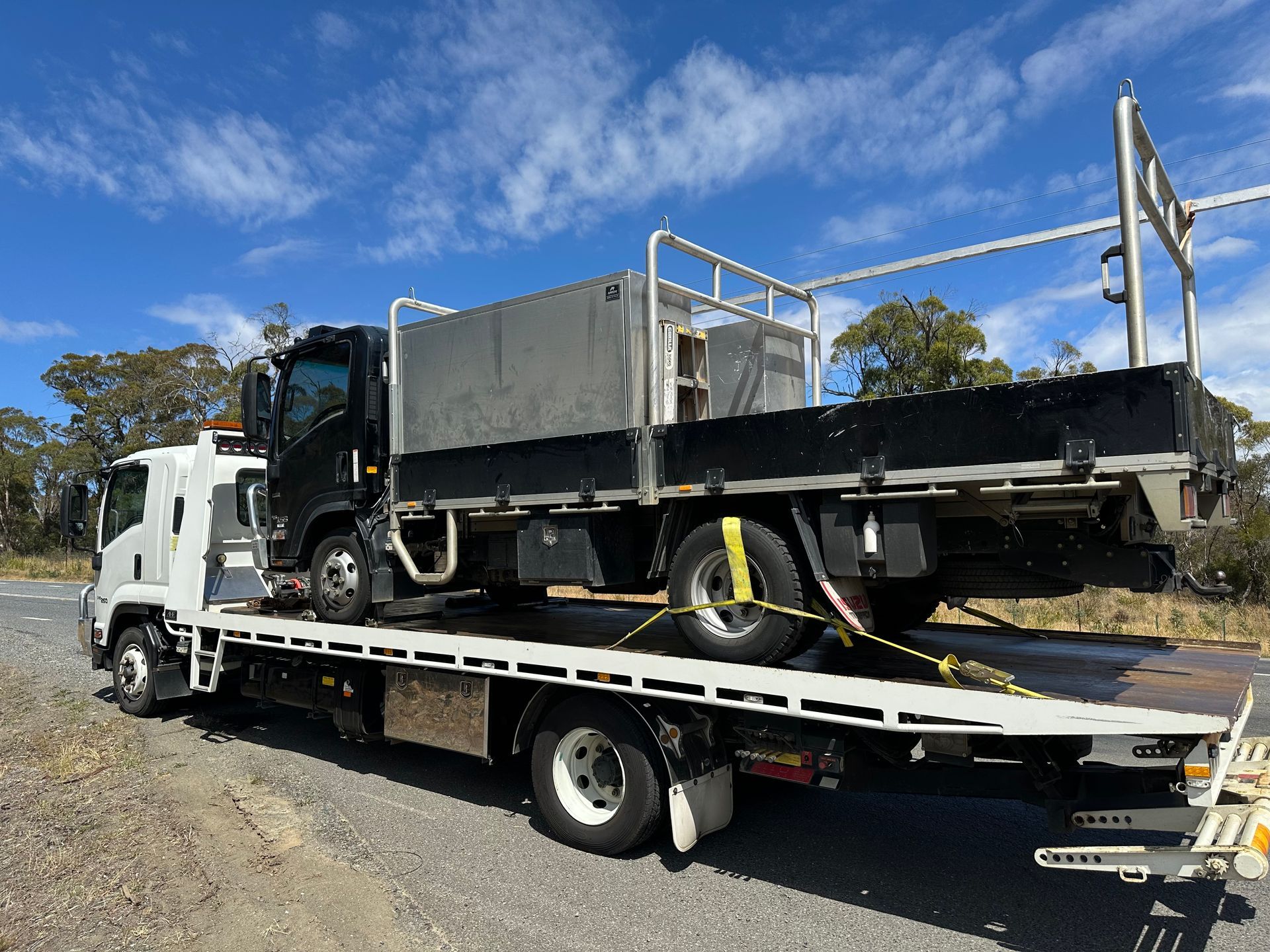 Tow Truck Hauling a Gray Dump Truck on A Flatbed Trailer — Connect Trailers and Towing Pty Ltd In Prospect Vale, TAS