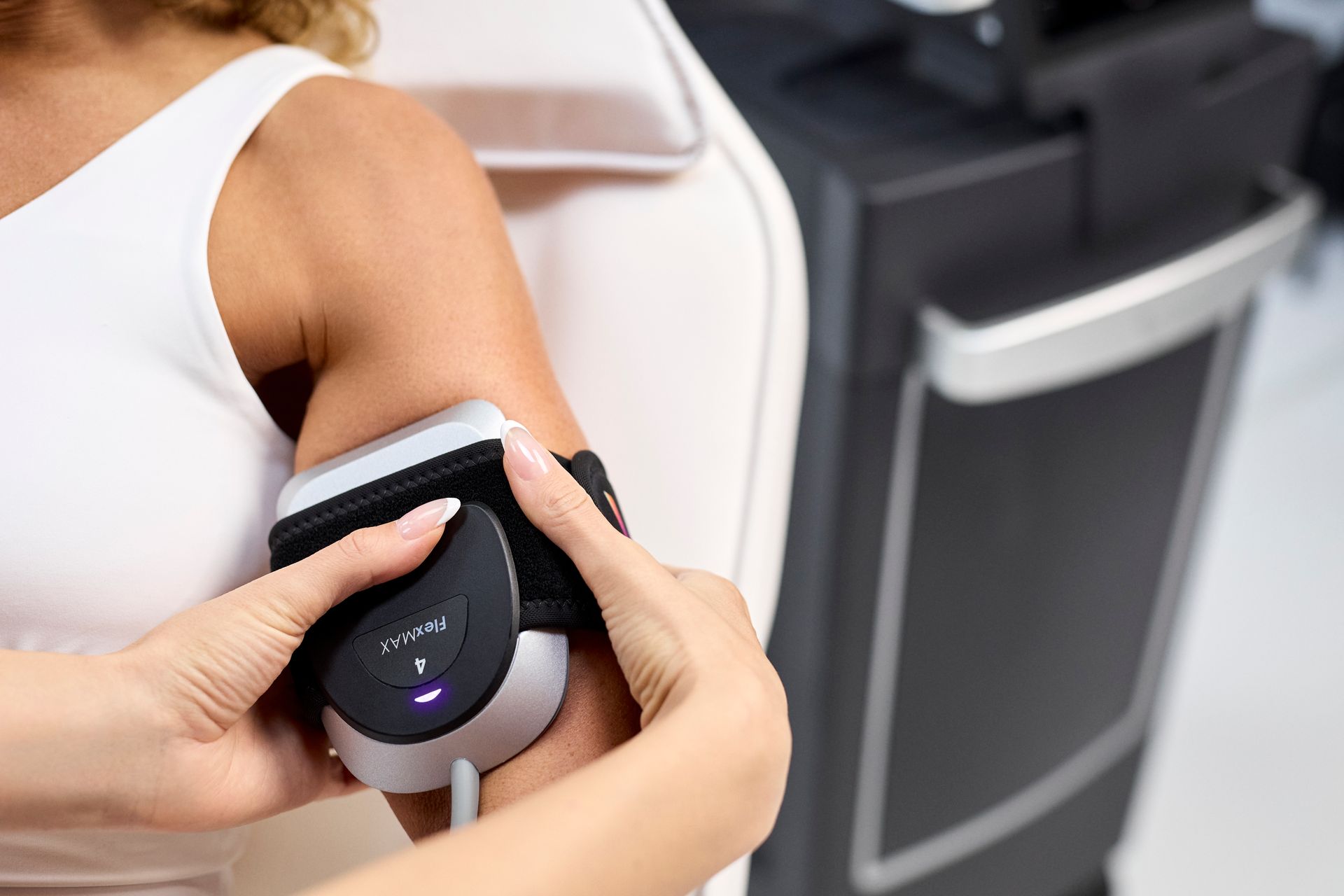 Person holding a blood pressure cuff on an arm in a clinical setting