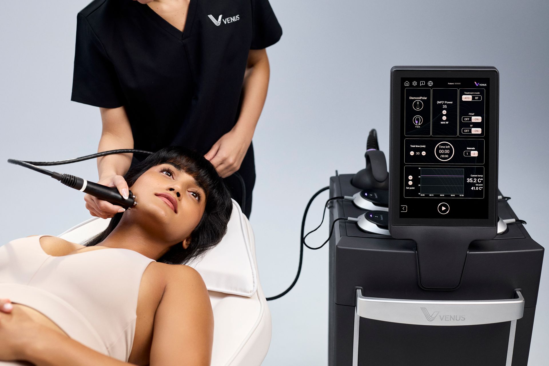 Woman receiving a neck treatment in a clinic beside a medical device display