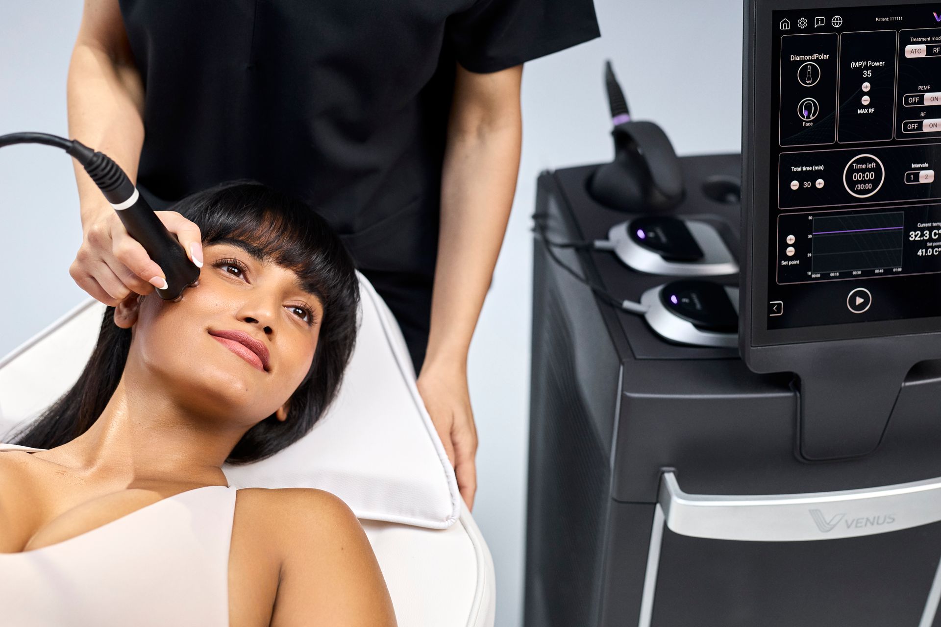 Woman receiving a facial treatment from a handheld device in a spa clinic room