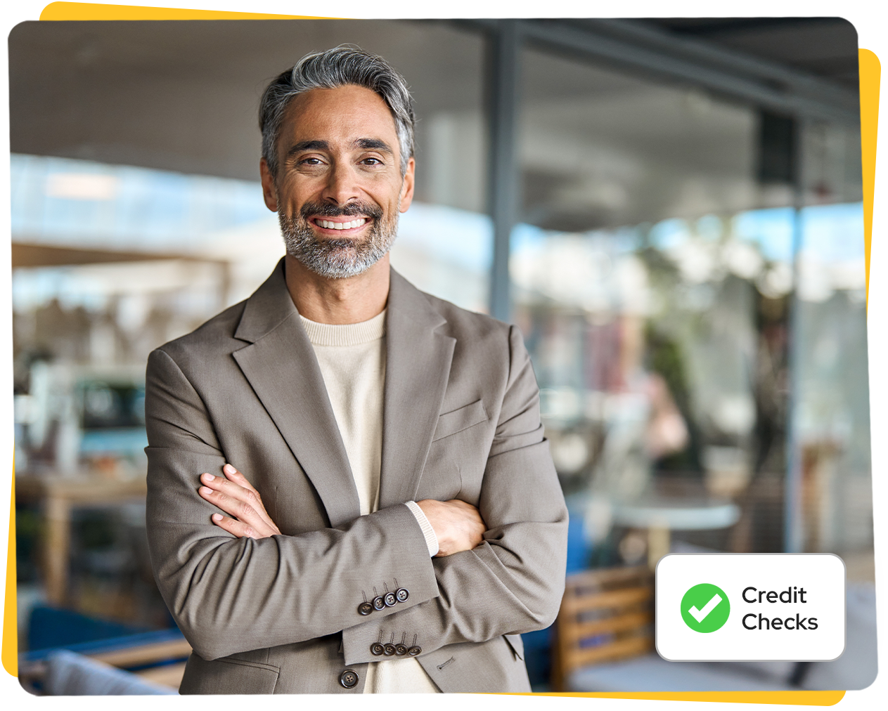 Smiling man in a blazer with arms crossed, in an office. Credit Checks logo.