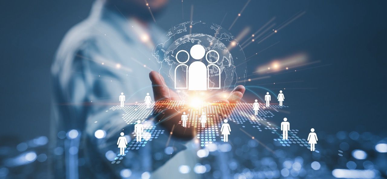 Person holding glowing digital network with people icons, suggesting interconnectedness.
