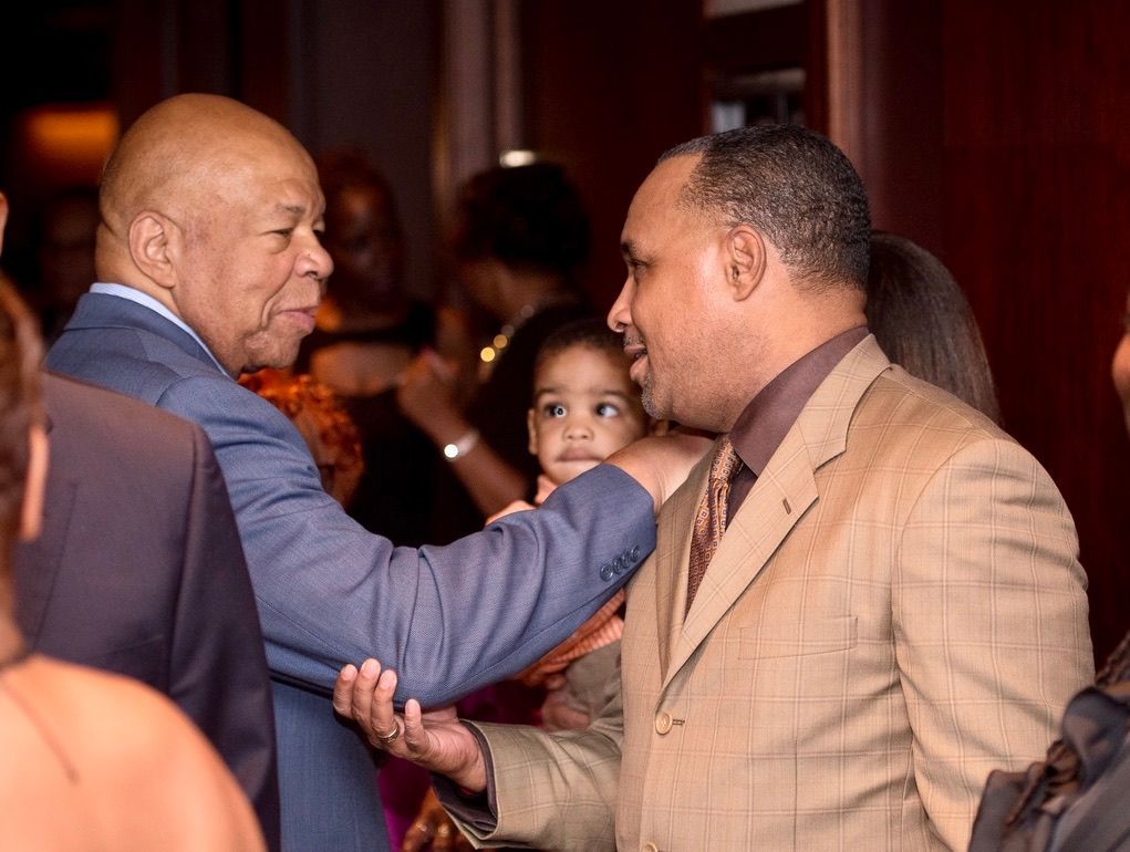 A man in a suit is shaking hands with another man.