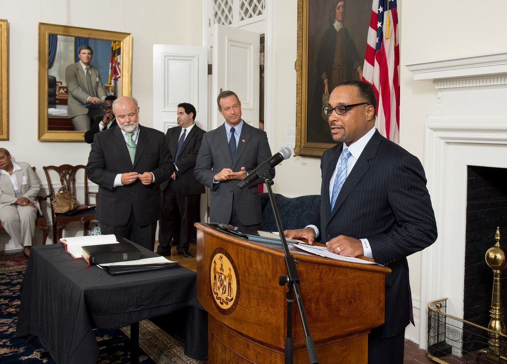 A man in a suit and tie is standing at a podium giving a speech.