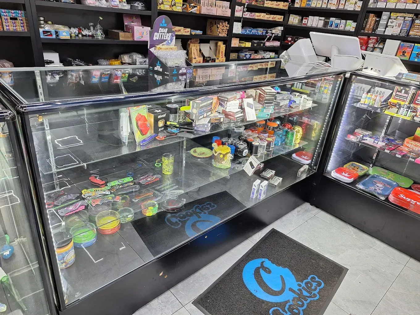 Glass display case of assorted colorful vape products and accessories in a shop.