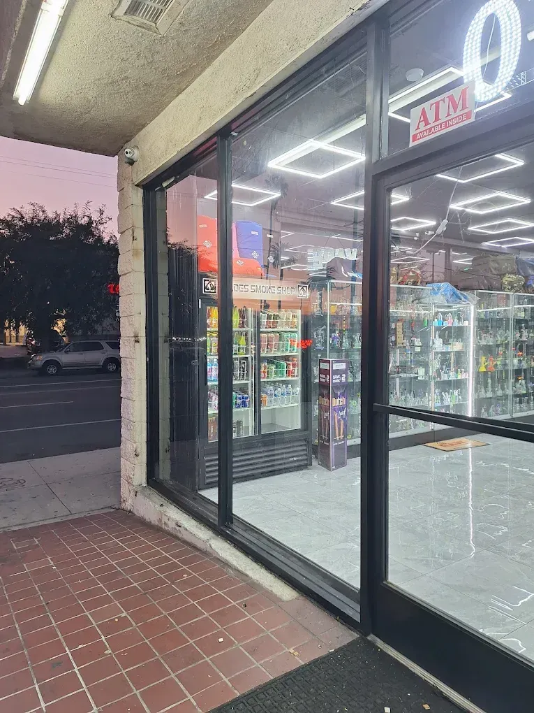 Storefront entrance with glass doors and bright interior lights at dusk