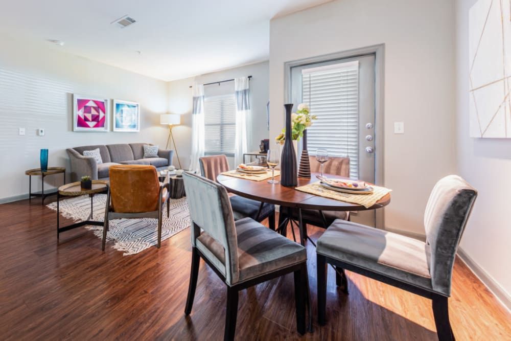a living room with a dining table and chairs and a couch at Marquis at Katy in Katy, TX.