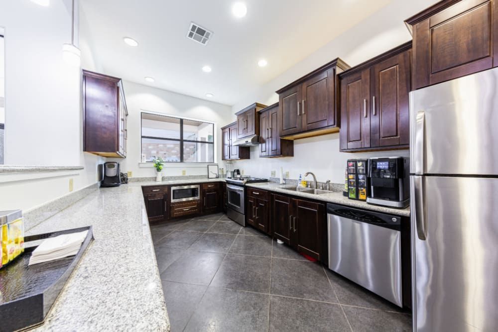 a kitchen with stainless steel appliances and wooden cabinets at Marquis at Katy in Katy, TX.