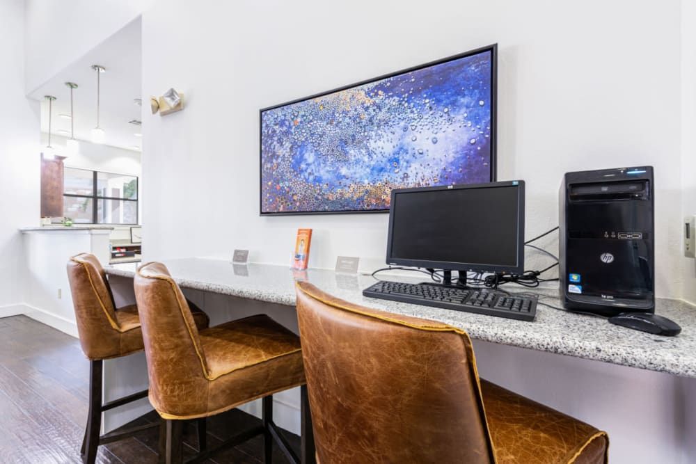 a computer desk with two chairs and a computer on it at Marquis at Katy in Katy, TX.