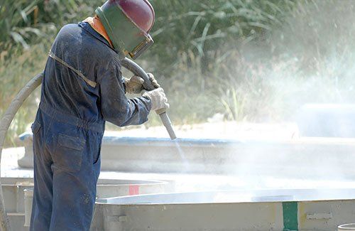 Worker Removing Paint by Sandblasting — Linn Grove, IA — Hare Painting & Sandblasting Worker Removing Paint by Sandblasting — Linn Grove, IA — Hare Painting & Sandblasting