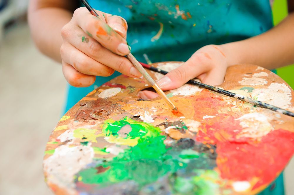 Lady holding a paint pallete doing art therapy - Adult Therapy on Wurtulla, QLD
