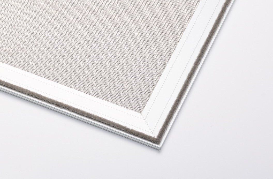 Un gros plan d'un écran de fenêtre avec un cadre blanc sur une surface blanche.