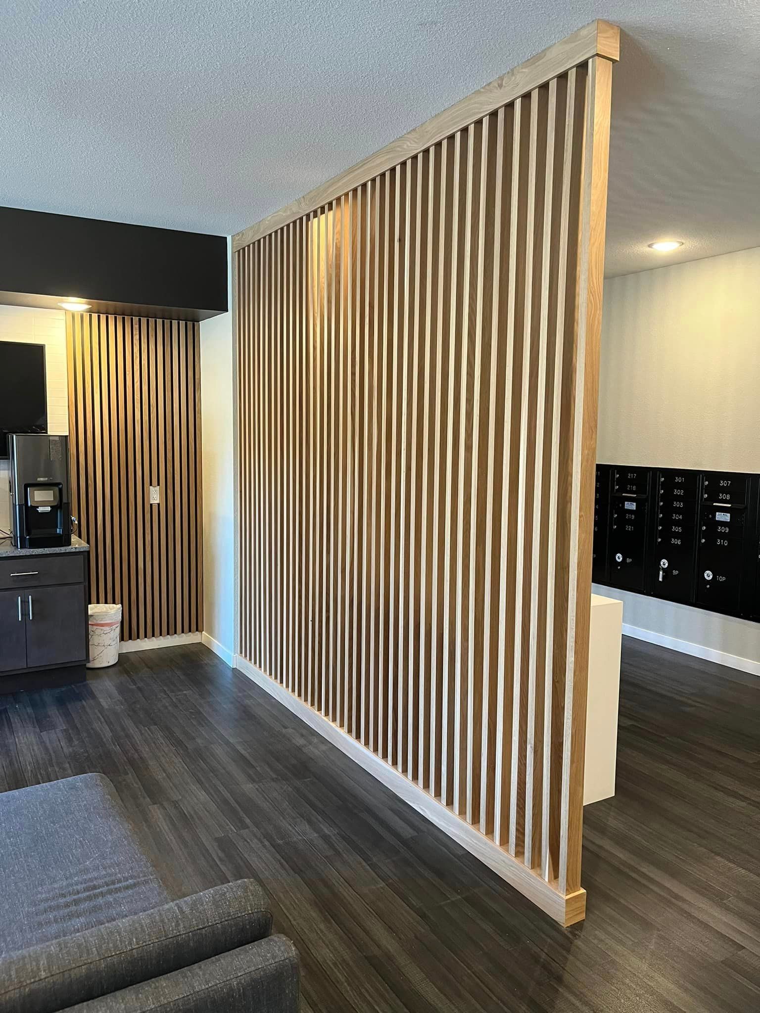 A living room with a wooden divider between the living room and the kitchen.