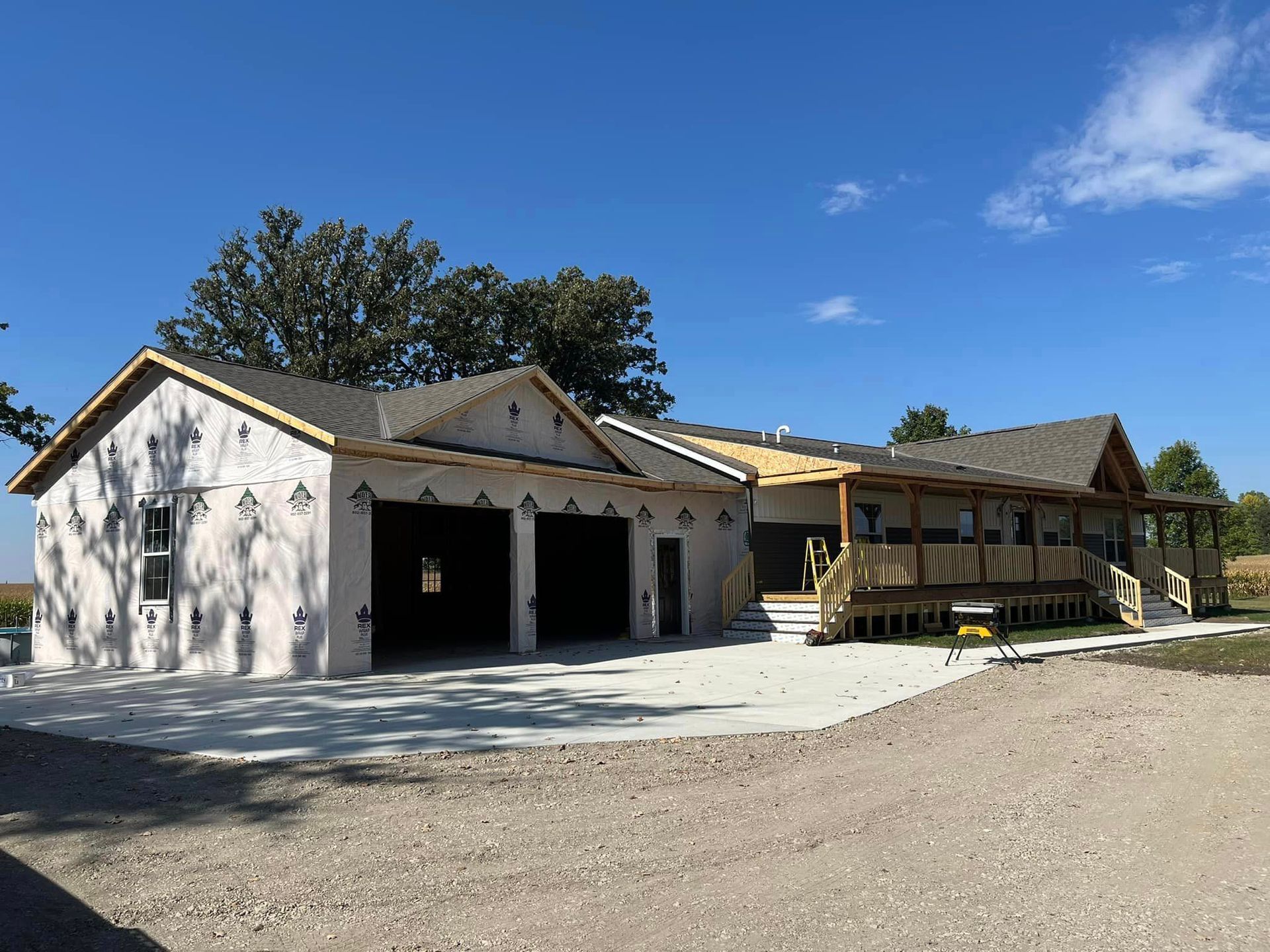 A large house is being built on a dirt road.