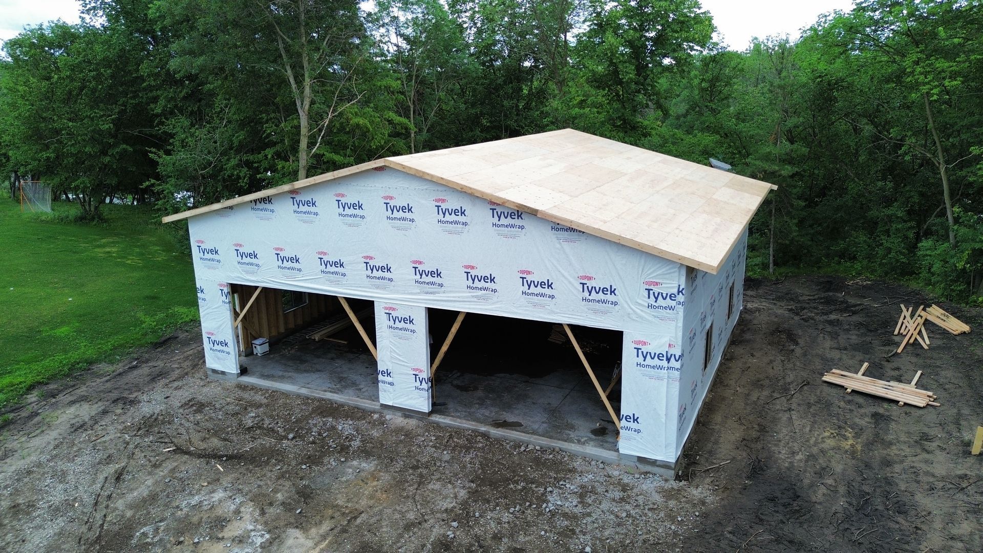 An aerial view of a garage under construction in the middle of a field.