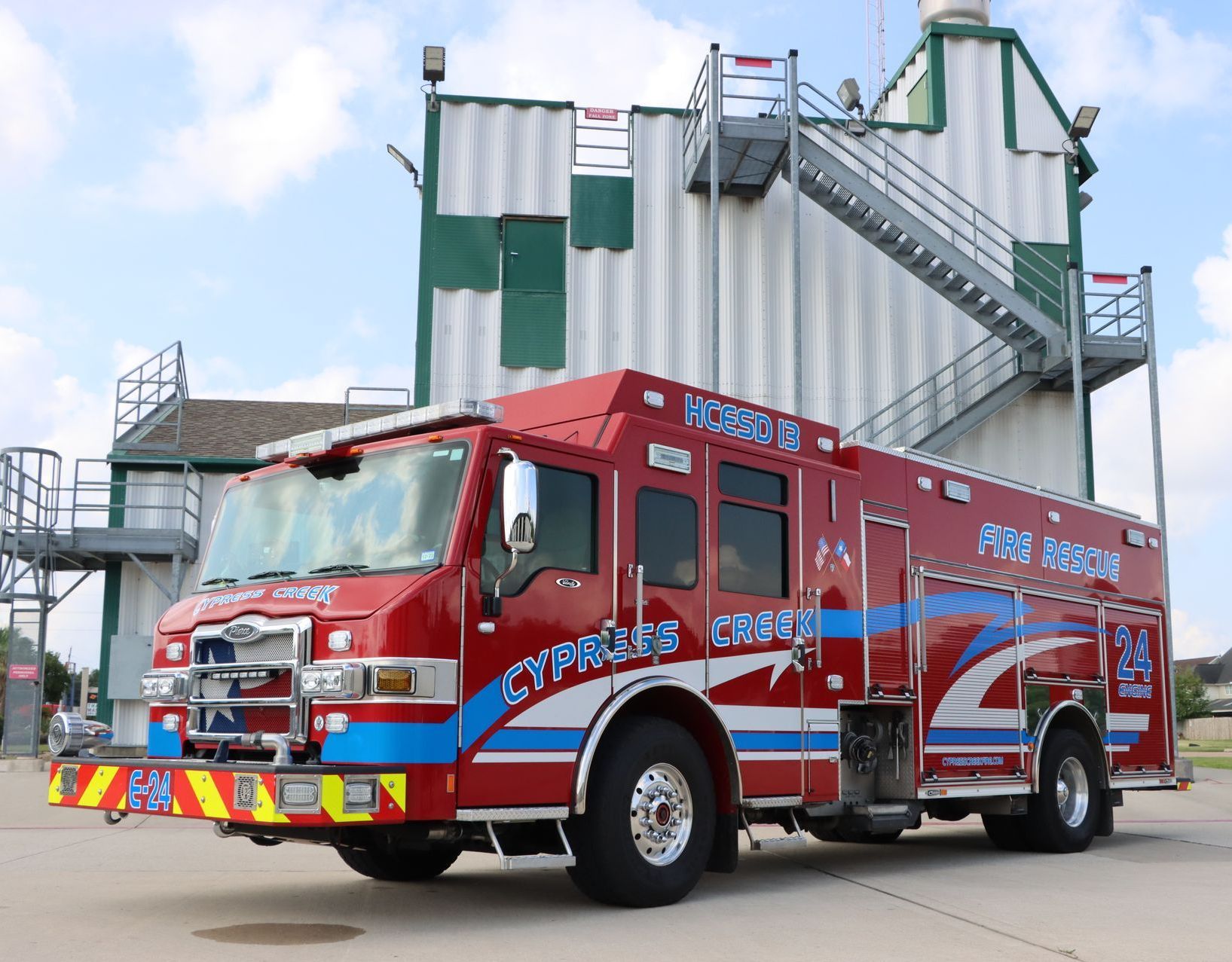 A red and blue fire truck is parked in front of a building. Cypress Creek engine 24.