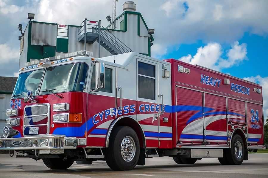 A red and white fire truck is parked in front of a building. Cypress Creek Heavy rescue 24.