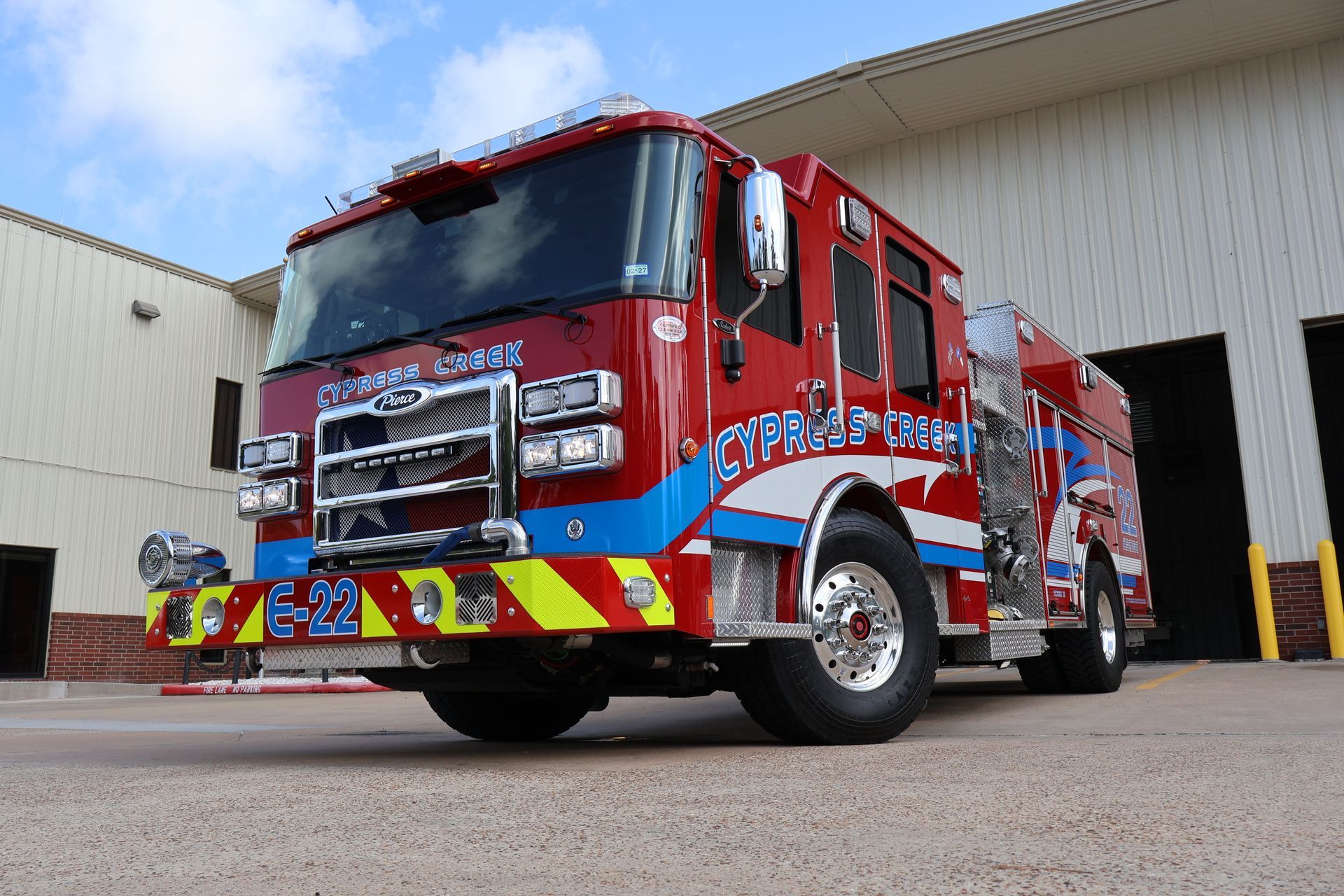 A red and blue fire truck is parked in front of a garage. Cypress Creek engine 22