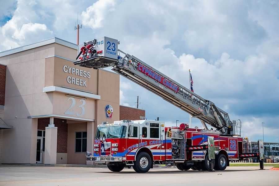 A fire truck is parked in front of a building that says cypress creek. Cypress Creek Tower 23.