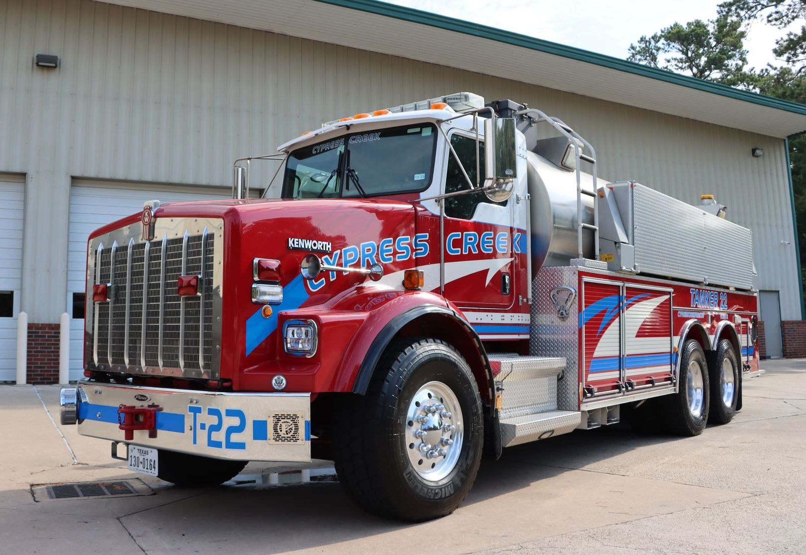 A red and blue fire truck is parked in front of a building. Cypress Creek Tanker 22.