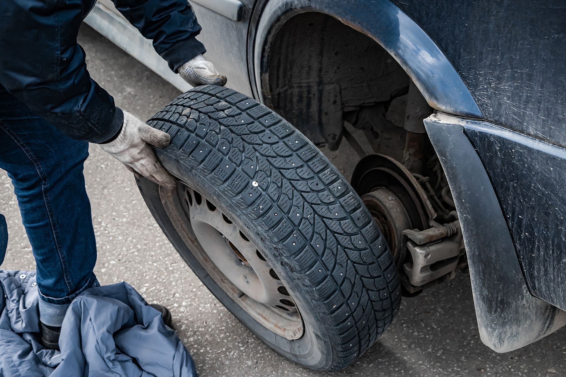 A man is changing a tire on a car.