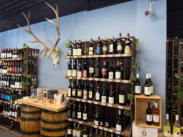 Rack of Italian red wines beside barrel bar table