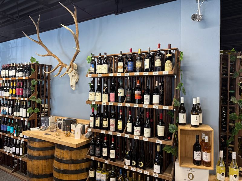 Rack of Italian red wines beside barrel bar table