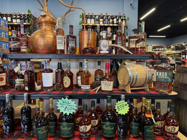 Rye and bourbon bottles beside a copper still