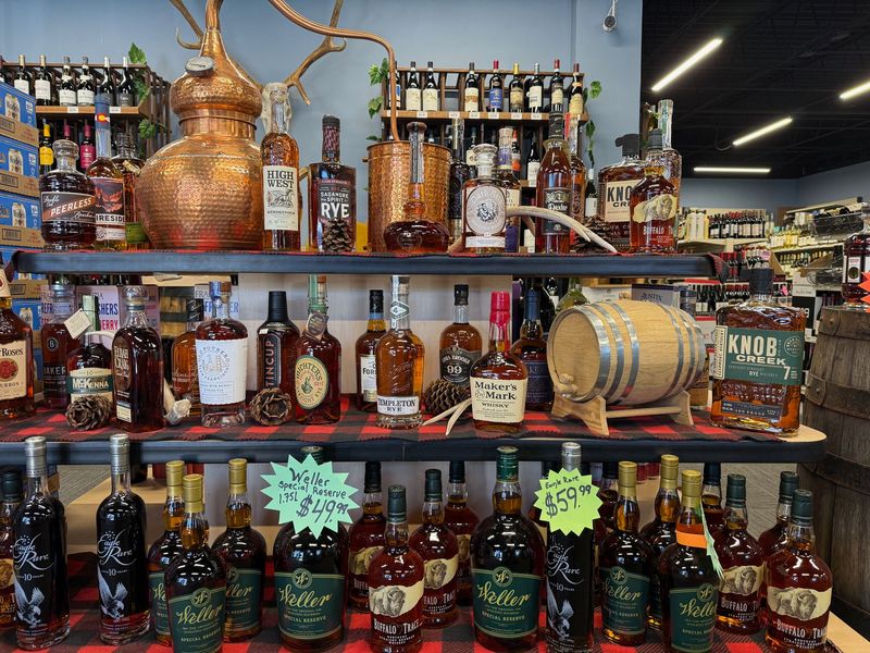 Rye and bourbon bottles beside a copper still