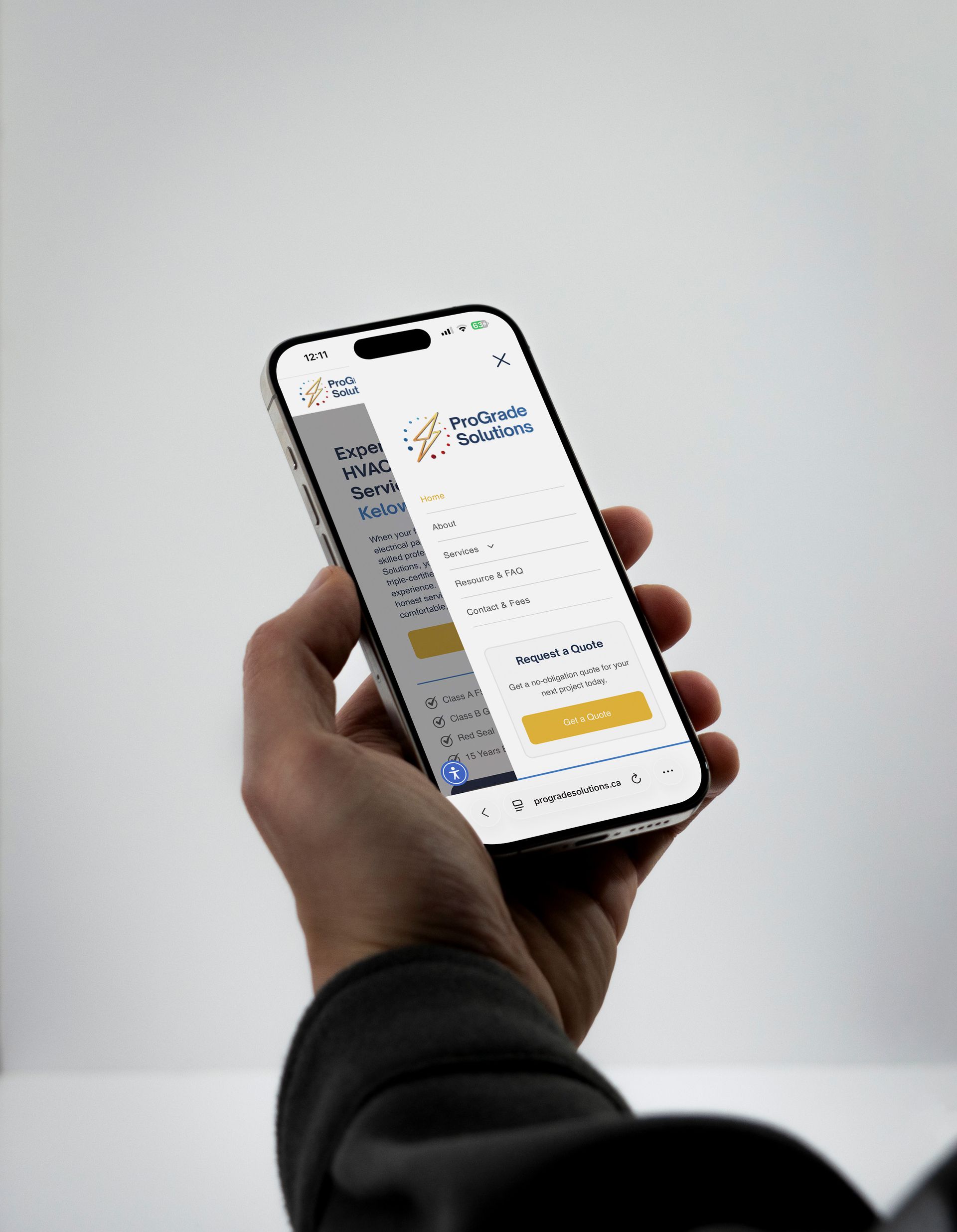 Person's hand holding a smartphone displaying a webpage, likely a website.