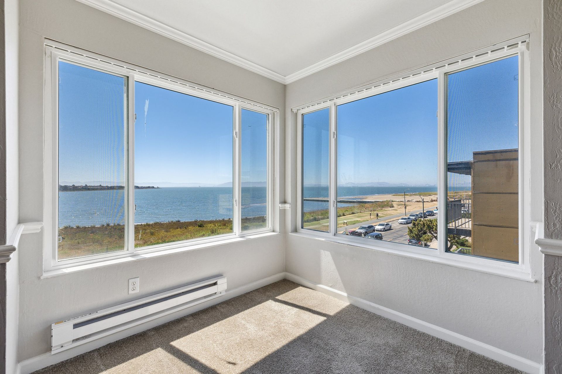 Corner living area with large bay windows and an ocean view at Tower apartments in Alameda, CA.