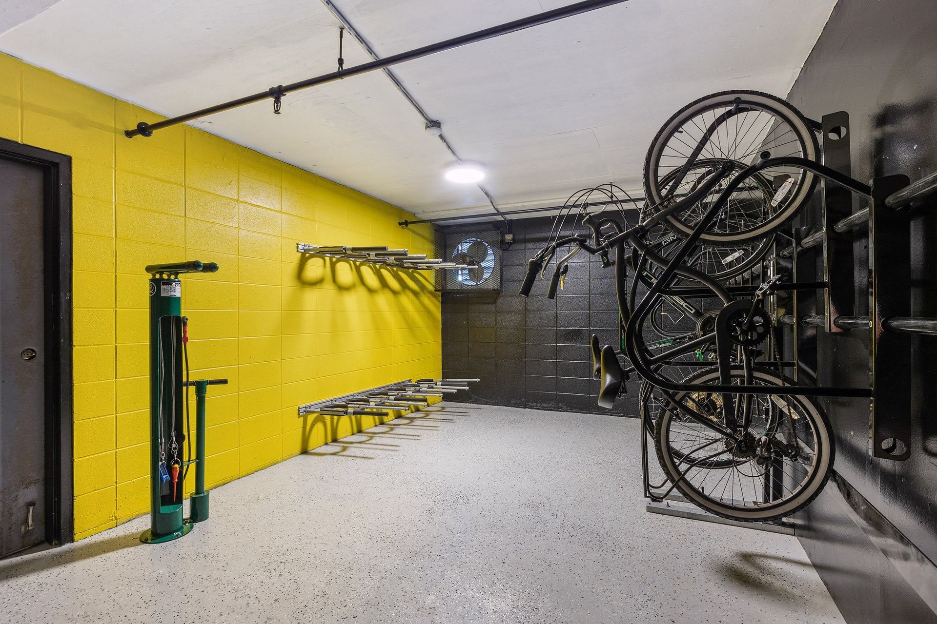 Bike storage room with bicycles mounted on a rack next to a yellow wall at Tower apartments in Alameda, CA.